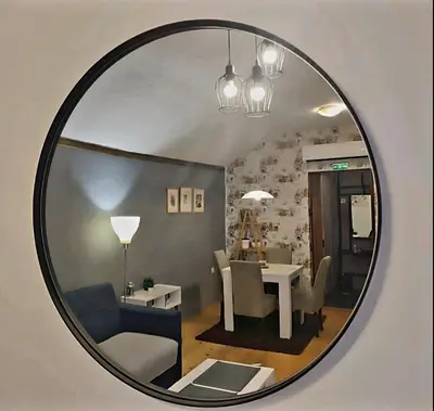 a mirror reflecting a living room with a table and chairs at Kum Apartment in Niš