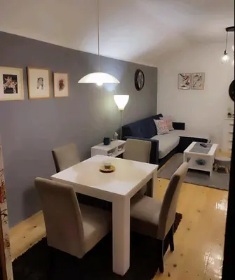 a living room with a white table and chairs at Kum Apartment in Niš