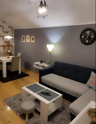 a living room with a couch and a table at Kum Apartment in Niš