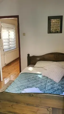 a bed with a wooden frame in a bedroom at Kum Apartment in Niš