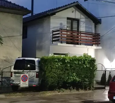 a white van parked in front of a house at Kum Apartment in Niš