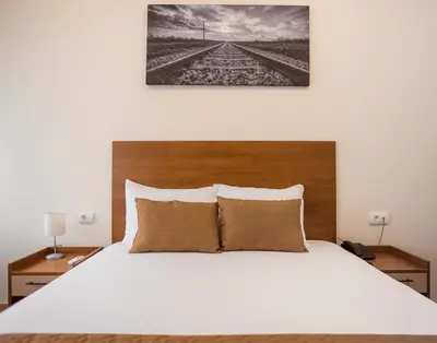 a bedroom with a large white bed with two night stands at Sajam B&B in Leskovac
