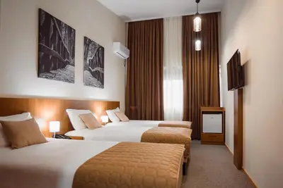 a hotel room with two beds and a television at Sajam B&B in Leskovac