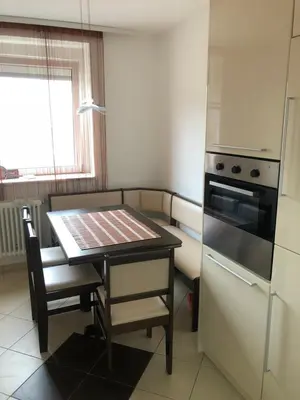 a kitchen with a table and a stove and a refrigerator at Tanja apartman in Jagodina