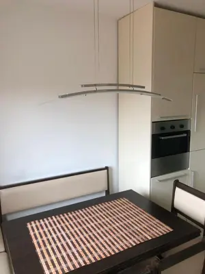 a kitchen with a table and a chandelier at Tanja apartman in Jagodina