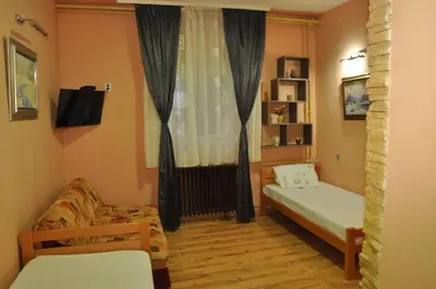 a room with a bed and a couch and a window at Eco Kop in Kopaonik