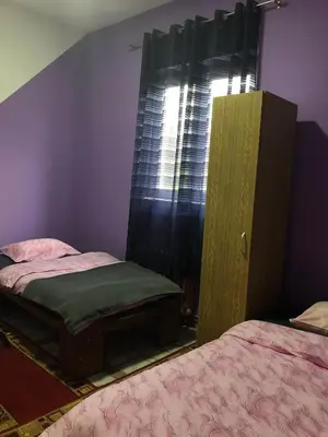 a bedroom with two twin beds and a window at Swiss Hostel in Kruševac