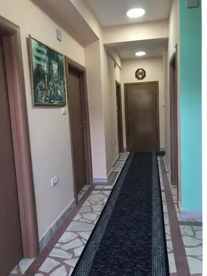 a hallway of a hotel with a door and a carpet at Swiss Hostel in Kruševac