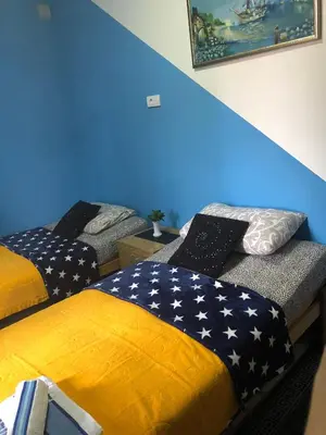 two beds in a room with an american flag blanket at Swiss Hostel in Kruševac