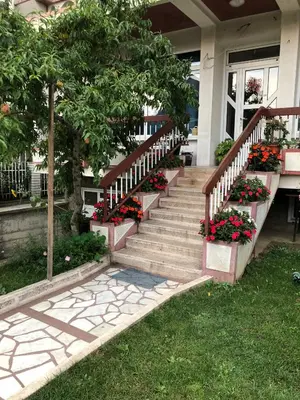 a house with a staircase with flowers on it at Swiss Hostel in Kruševac