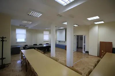 a conference room with a table and chairs and a screen at Hostel Teresianum in Aleksinac