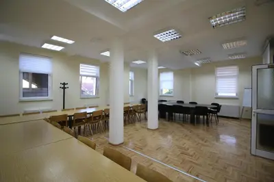 a large room with a dining table and chairs at Hostel Teresianum in Aleksinac