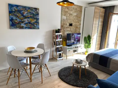 a living room with a bed and a table and chairs at Milmari Resort - Apartman L43 in Kopaonik