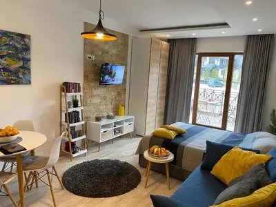 a living room with a blue couch and a table at Milmari Resort - Apartman L43 in Kopaonik