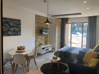 a bedroom and living room with a bed and a table at Milmari Resort - Apartman L43 in Kopaonik