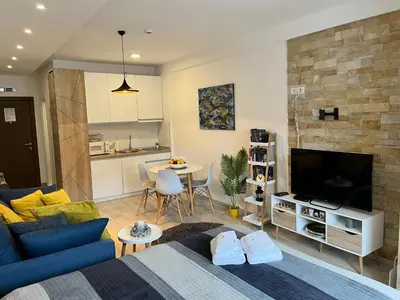 a living room with a blue couch and a tv at Milmari Resort - Apartman L43 in Kopaonik