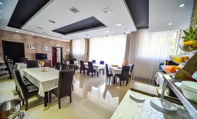 a dining room with tables and chairs in a restaurant at Garni Hotel 018 In in Niš