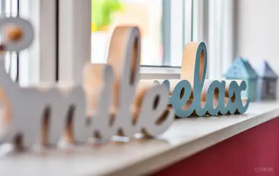 a shelf with a wooden block spelling out the word home at Garni Hotel 018 In in Niš
