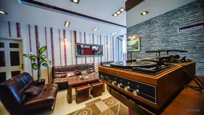 a living room with a stove and a leather couch at Garni Hotel 018 In in Niš