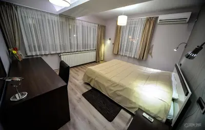 a small bedroom with a bed and a desk at Garni Hotel 018 In in Niš
