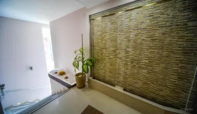 a large brick wall in a room with a potted plant at Garni Hotel 018 In in Niš