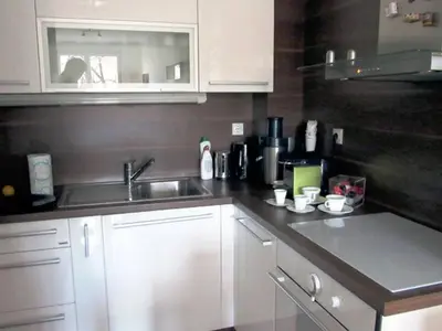 a kitchen with white cabinets and a sink at River View Nis - 65 square meters Designer Apartment in heart of city Park for free in Niš