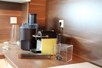 a coffee maker sitting on a wooden counter top at River View Nis - 65 square meters Designer Apartment in heart of city Park for free in Niš