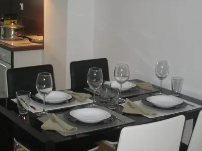 a table with plates and wine glasses on it at River View Nis - 65 square meters Designer Apartment in heart of city Park for free in Niš