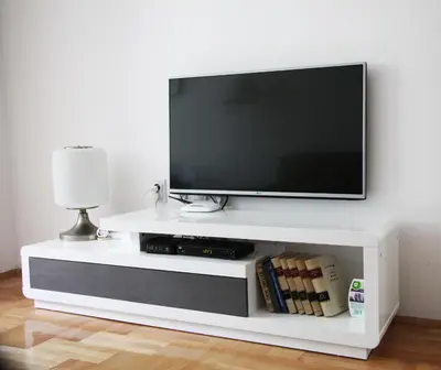 a flat screen tv sitting on a white entertainment center at River View Nis - 65 square meters Designer Apartment in heart of city Park for free in Niš