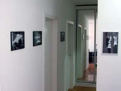 a hallway with pictures on the wall and a mirror at River View Nis - 65 square meters Designer Apartment in heart of city Park for free in Niš