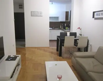 a living room with a couch and a table at River View Nis - 65 square meters Designer Apartment in heart of city Park for free in Niš