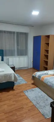 a bedroom with two beds and rugs on a wooden floor at Apartman Aleksic in Jagodina