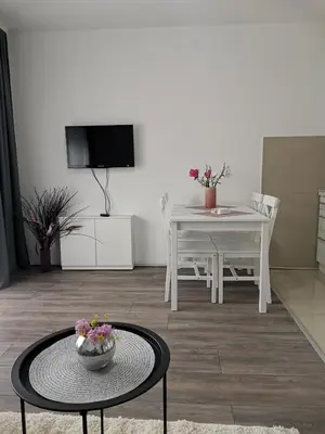 a living room with a table and a dining room at Apartman Aleksic in Jagodina