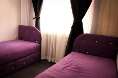 a bedroom with a purple couch and a window at Vladana DELUXE App 2 in Kruševac
