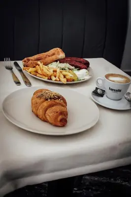 a table with two plates of food and a cup of coffee at Vladana DELUXE App 2 in Kruševac