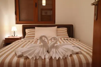 two white swans are sitting on a bed at Apartman Nensy in Vrnjačka Banja