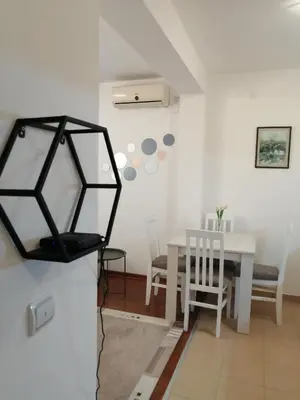 a dining room with a white table and chairs at Apartman Nensy in Vrnjačka Banja