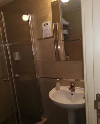 a bathroom with a sink and a shower with a mirror at Apartman Masa Kopaonik in Kopaonik