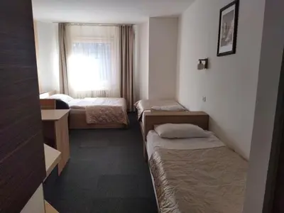a hotel room with three beds and a window at Apartman Masa Kopaonik in Kopaonik