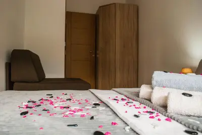 a bed with pink rose petals on it at Apartman Soko in Soko Banja