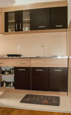 a kitchen with black cabinets and a sink at Apartman Soko in Soko Banja