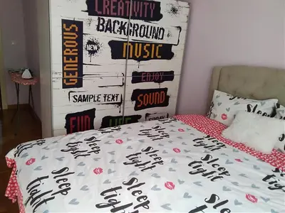 a bedroom with a bed and a wall with signs at apartman Vita in Vrnjačka Banja