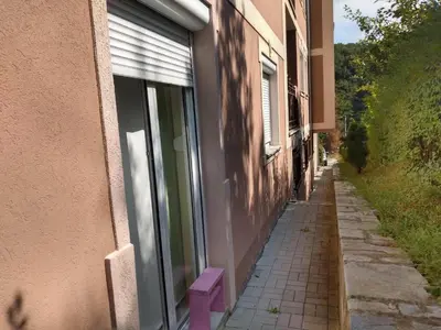 a building with a purple bench on the side of a street at apartman Vita in Vrnjačka Banja