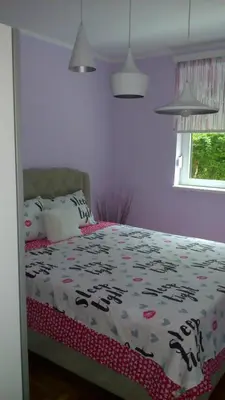 a bedroom with a bed with a floral comforter at apartman Vita in Vrnjačka Banja