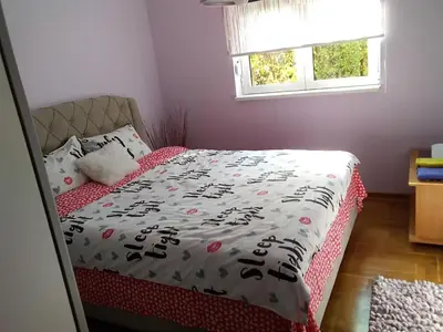 a bedroom with a bed with a comforter and a window at apartman Vita in Vrnjačka Banja