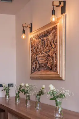 a tapestry hanging on a wall with vases of flowers at Hotel Aloha in Niš