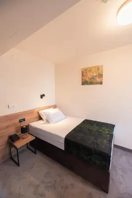 a bedroom with a bed and a table in it at Hotel Aloha in Niš