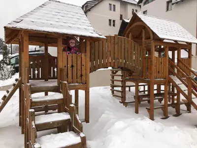 a child in a gazebo in the snow at Kopaonik Milmari apartman L33 in Kopaonik