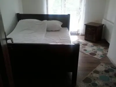 a bedroom with a bed and a chair and a window at Sobe Nevenka in Vrnjačka Banja