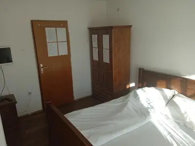 a bedroom with a bed and a wooden door at Sobe Nevenka in Vrnjačka Banja